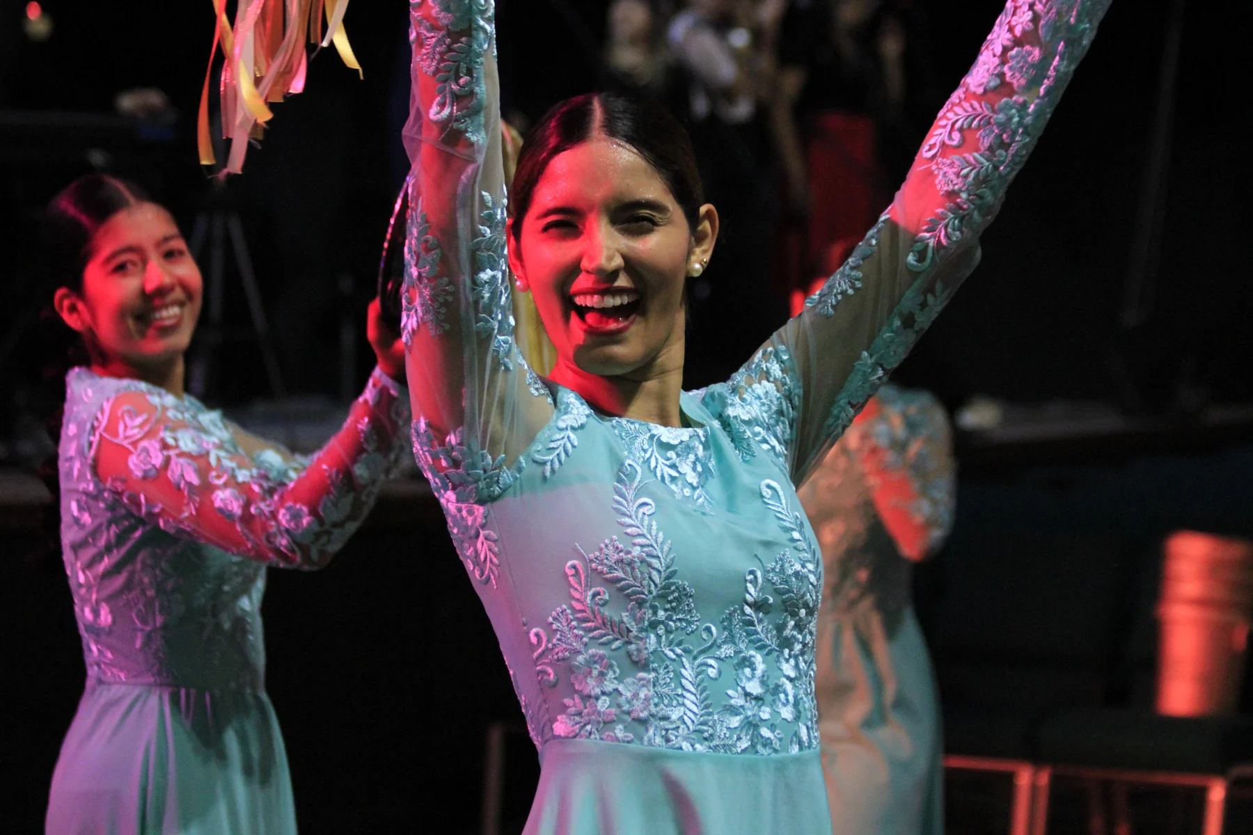 Integrantes del equipo de danzas con los brazos levantados